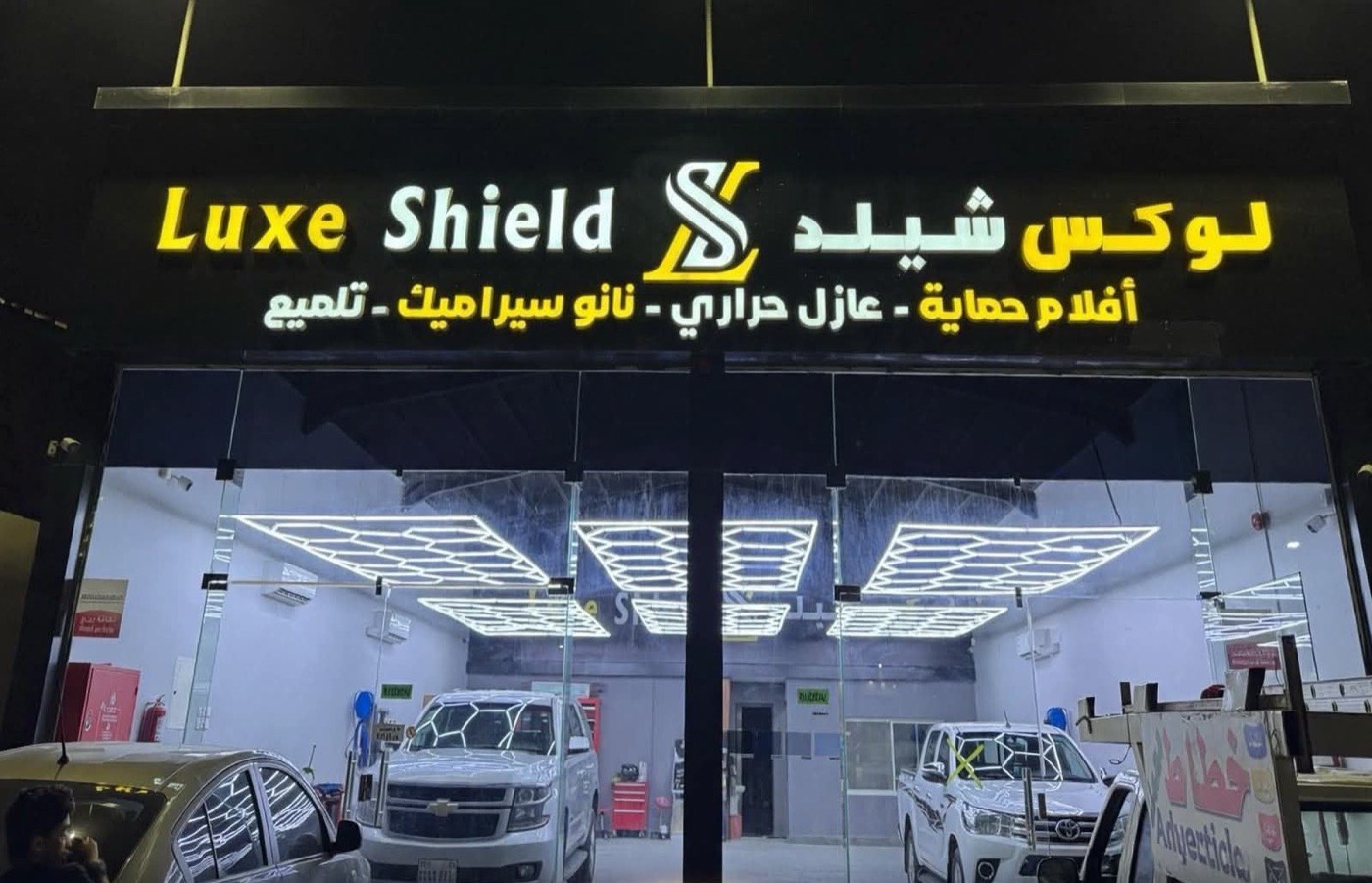View into the Luxe Shield studio through the glass front, with cars inside